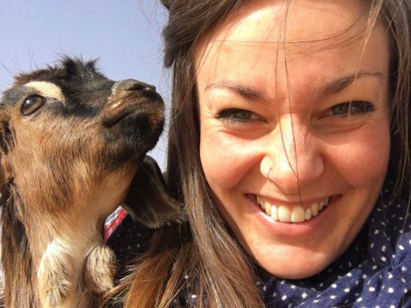 Smiling woman and a little goat