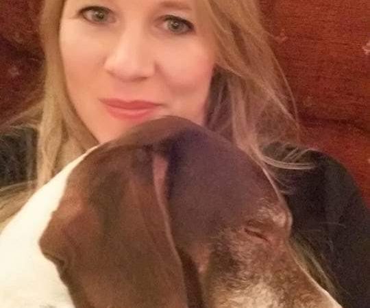 Smiling blonde woman and her sleeping dog