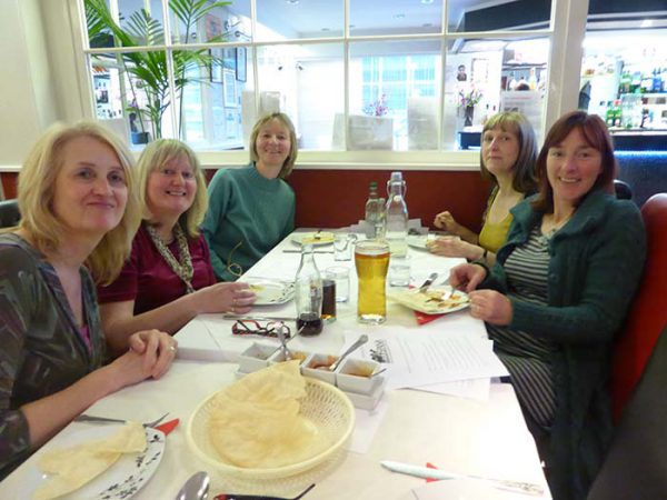 Group of women sat around table in restaurant