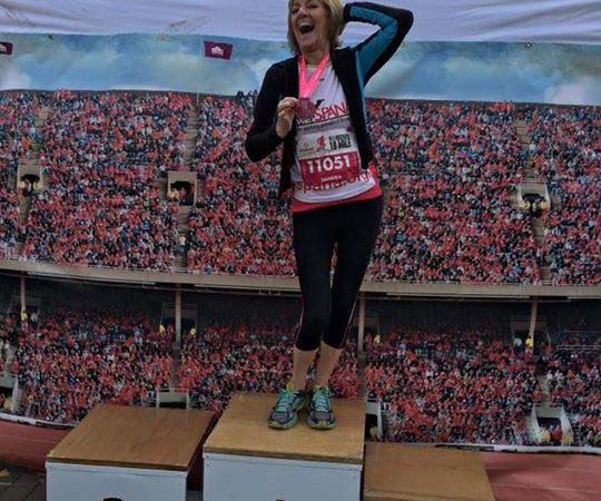 Smiling woman standing on top of winners podium
