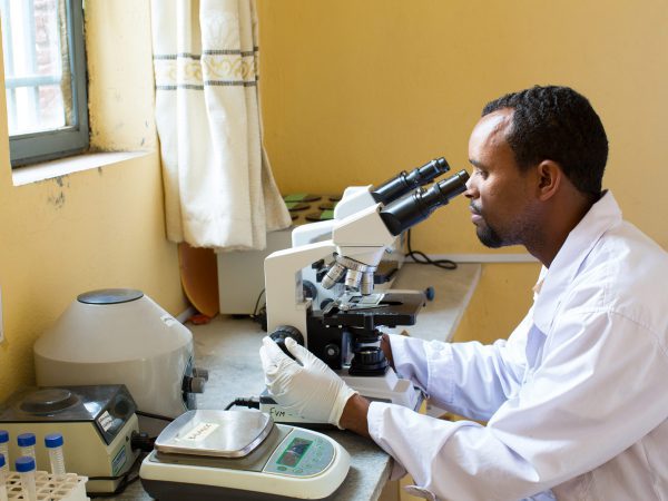 Vet looking through microscope
