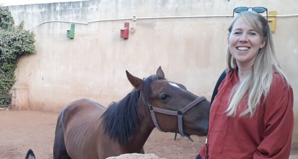 woman standing with a donkey
