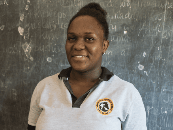 Diana stands in front of the blackboard