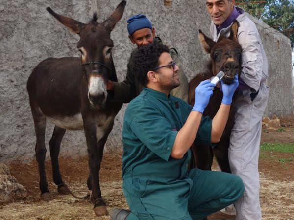 Najia stands with her mother while receiving follow up care at home outside of Chemaia