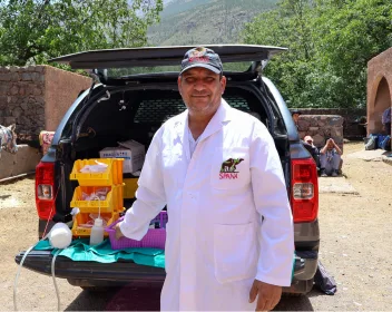 Dr Jaiber, SPANA veterinarian in Morocco stands next to his car at a mobile clinic