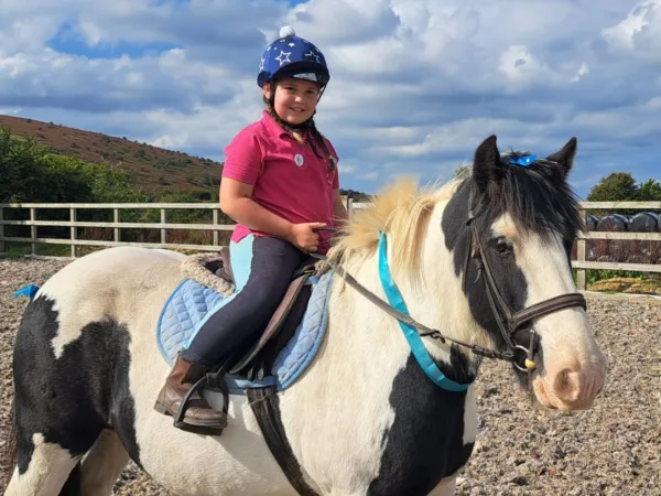 girl riding a black and white horse