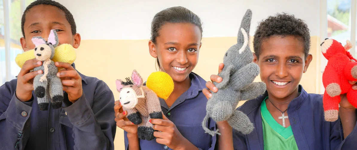 Three Children with knitted crocheted animals Ethiopia