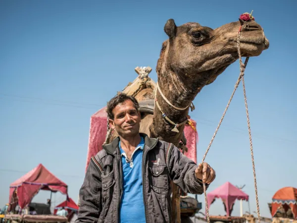Man standing next to camel