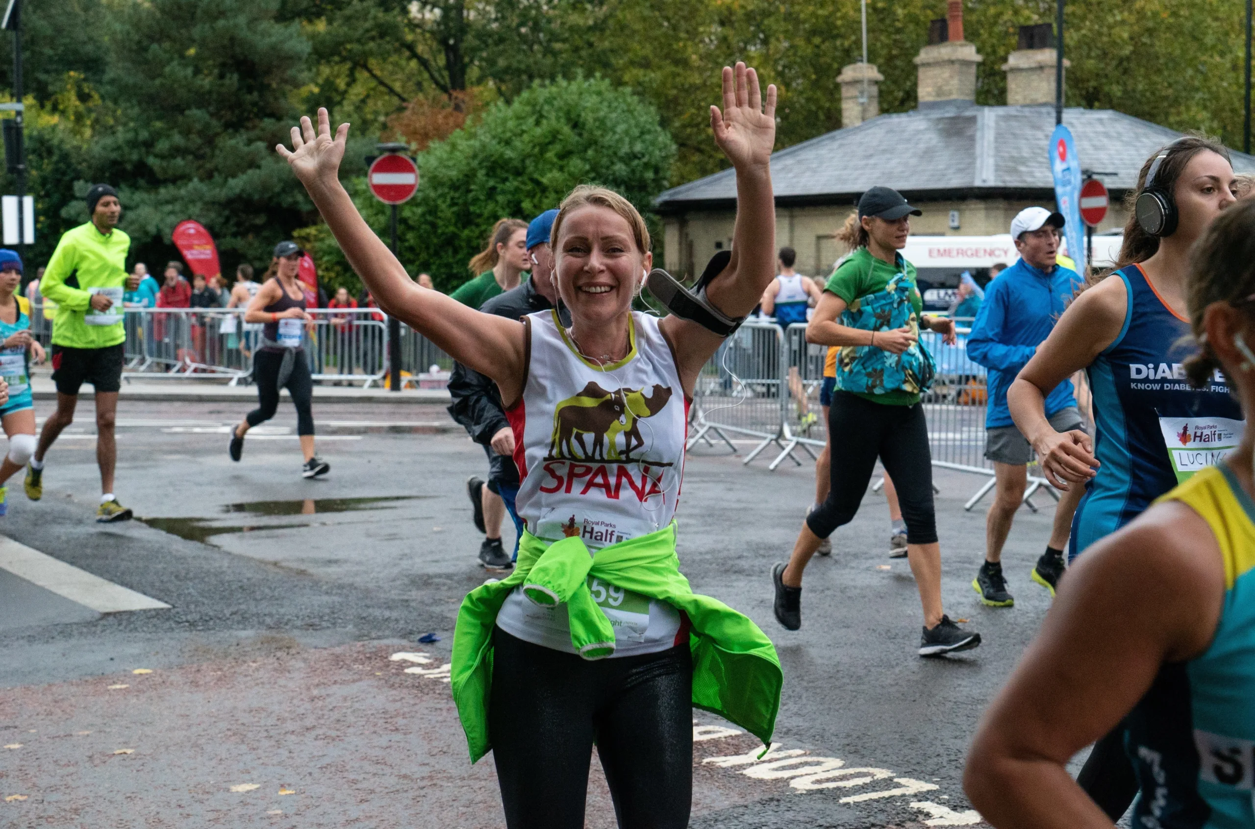 Woman celebrating SPANA run with arms raised at Royal Parks Half Marathon